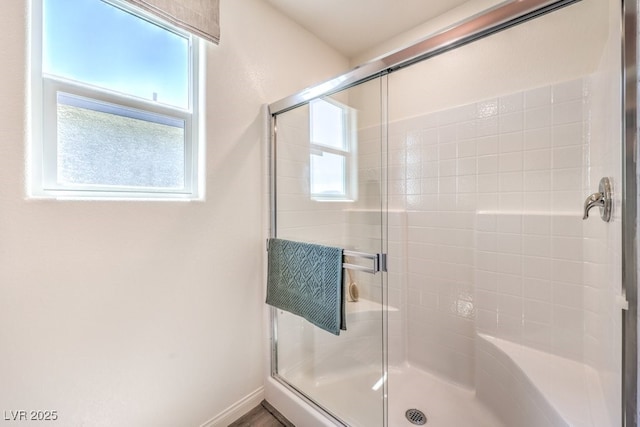 bathroom featuring baseboards and a shower stall