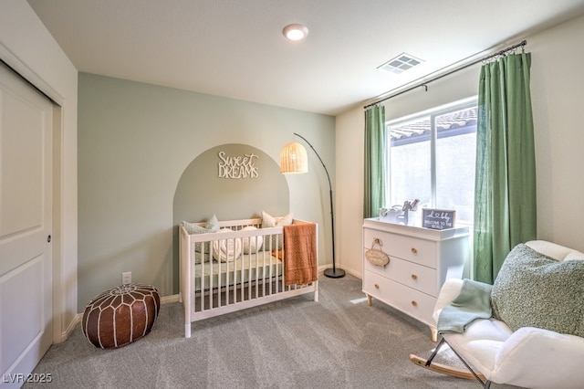 carpeted bedroom featuring visible vents, baseboards, and a closet