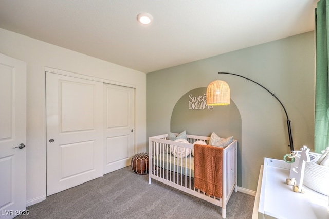 bedroom with a closet, a nursery area, and carpet