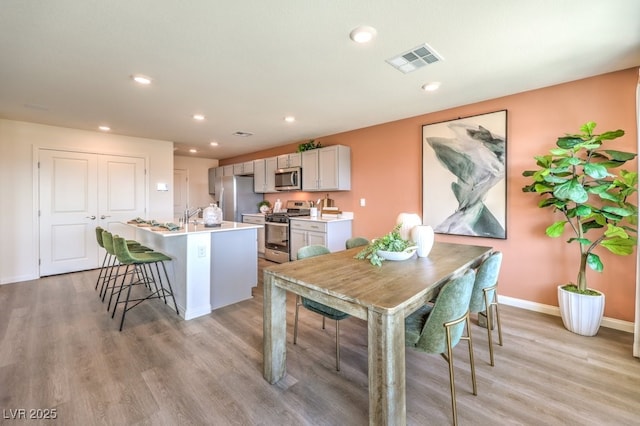 dining area featuring light wood-type flooring, visible vents, baseboards, and recessed lighting