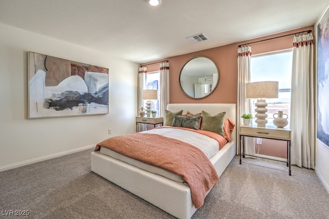 carpeted bedroom featuring baseboards and visible vents