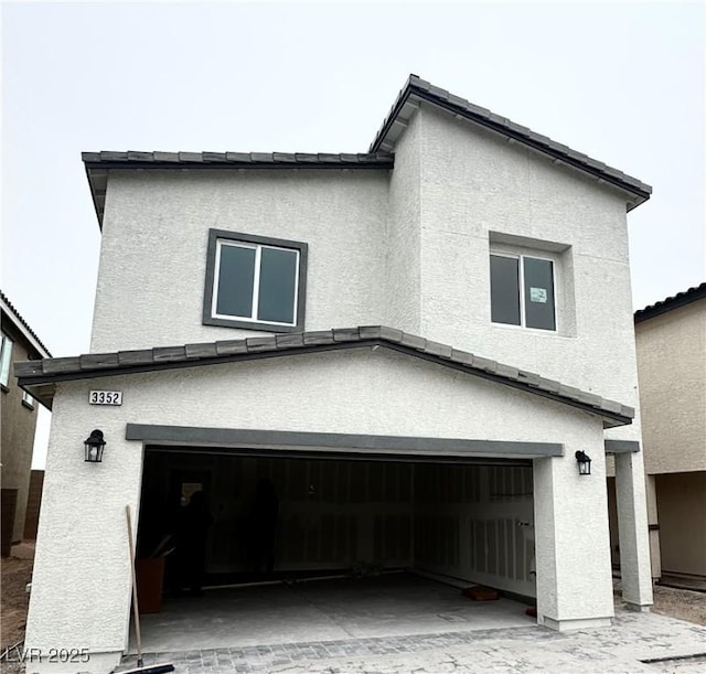 view of side of property featuring a garage and stucco siding