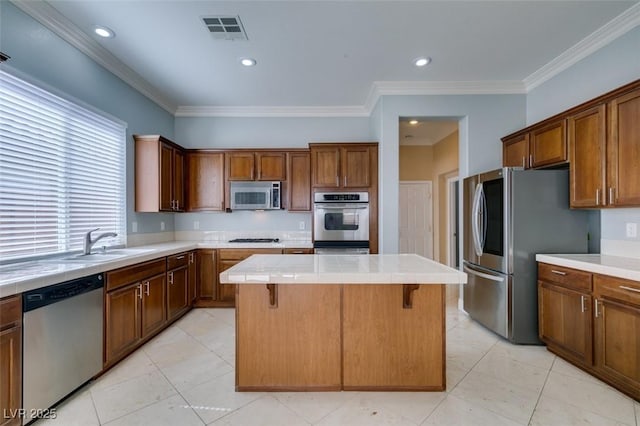 kitchen with visible vents, a sink, a kitchen breakfast bar, a kitchen island, and stainless steel appliances