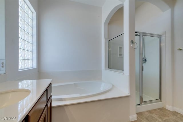 bathroom with tile patterned flooring, a shower stall, a bath, and vanity