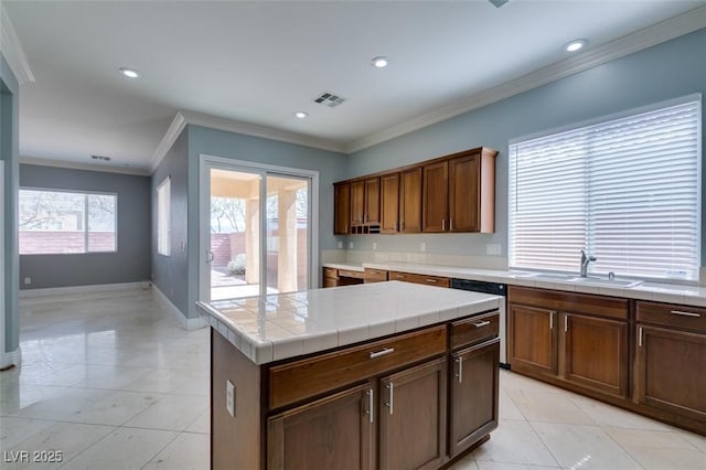 kitchen featuring crown molding, tile countertops, light tile patterned flooring, and a sink