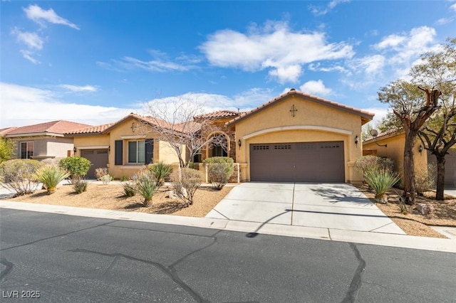 mediterranean / spanish-style house featuring stucco siding, a tiled roof, concrete driveway, and a garage