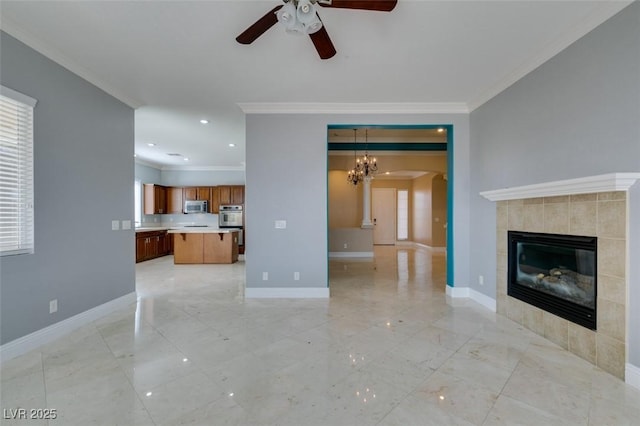 unfurnished living room with baseboards, ceiling fan with notable chandelier, a tile fireplace, and ornamental molding