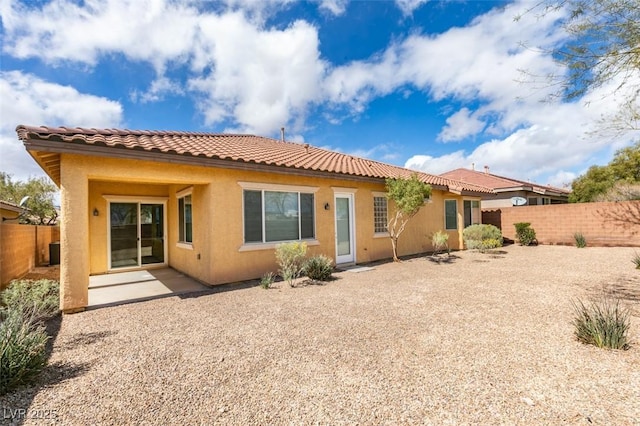 back of property featuring a patio, a tiled roof, a fenced backyard, and stucco siding