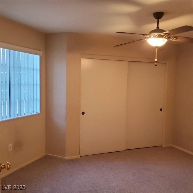 carpeted spare room with ceiling fan