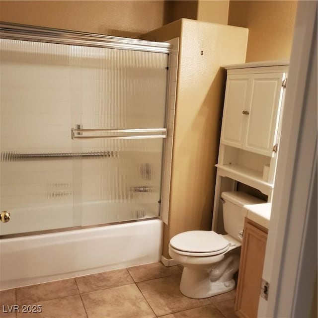 bathroom featuring tile patterned floors, vanity, toilet, and shower / bath combination with glass door