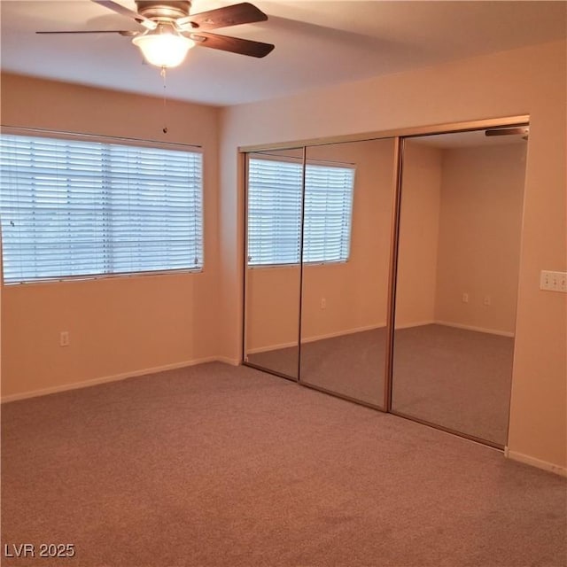 unfurnished bedroom featuring baseboards, carpet floors, a closet, and ceiling fan