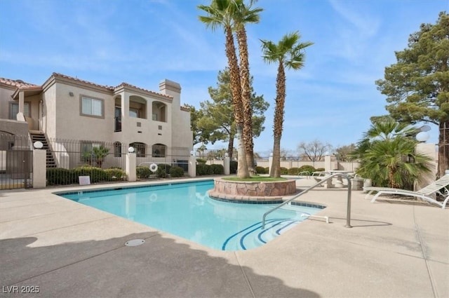 community pool featuring a patio area and fence