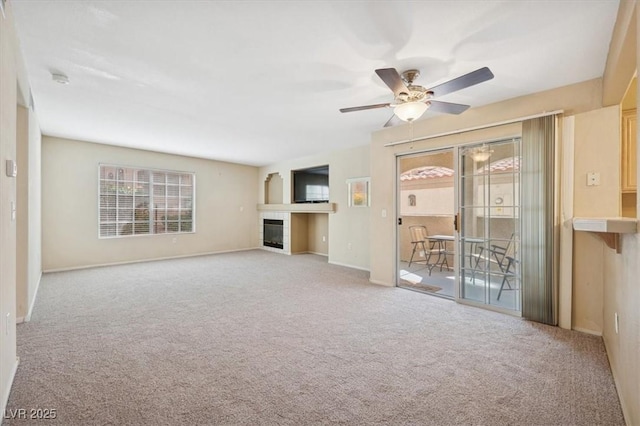 unfurnished living room with ceiling fan, carpet flooring, baseboards, and a fireplace