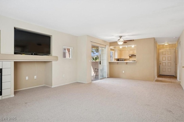 unfurnished living room with ceiling fan, carpet, and baseboards