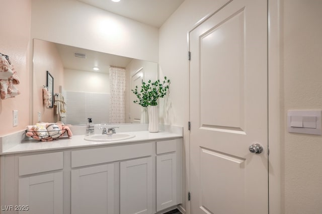 full bath featuring a tile shower and vanity