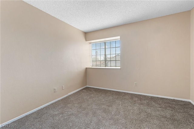 spare room featuring carpet flooring, baseboards, and a textured ceiling