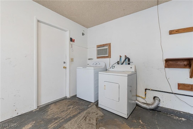 laundry room featuring laundry area, washing machine and dryer, and a textured ceiling