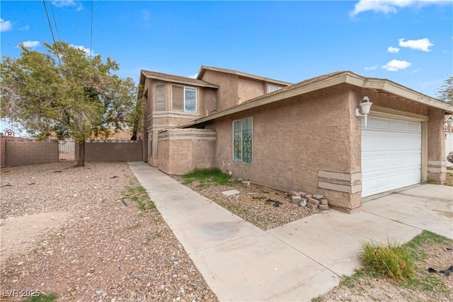 view of home's exterior with stucco siding, driveway, an attached garage, and fence