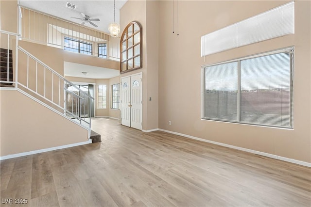 entryway with visible vents, a ceiling fan, wood finished floors, stairway, and baseboards