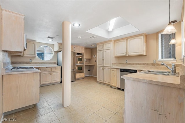 kitchen with a sink, appliances with stainless steel finishes, light brown cabinetry, and light countertops