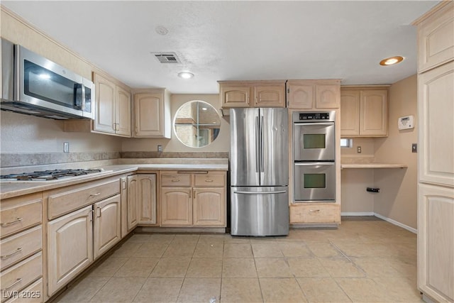 kitchen with stainless steel appliances, visible vents, and light brown cabinetry