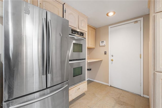 kitchen with light brown cabinets, baseboards, light countertops, light tile patterned flooring, and stainless steel appliances