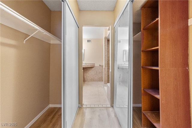 spacious closet with wood finished floors and visible vents