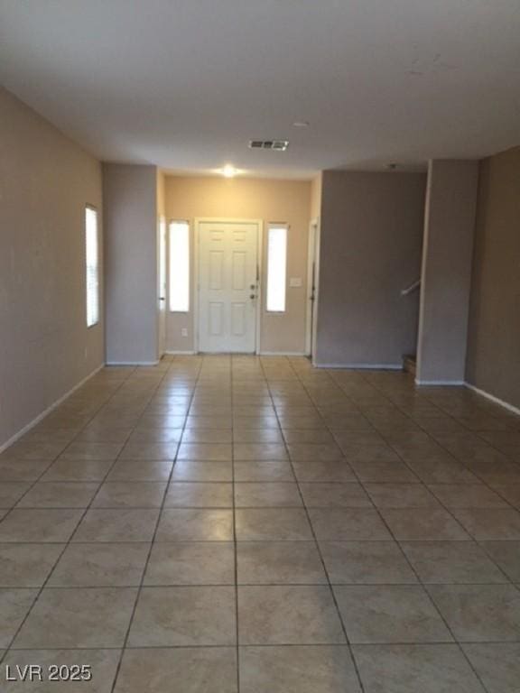 foyer entrance featuring light tile patterned flooring, baseboards, and visible vents