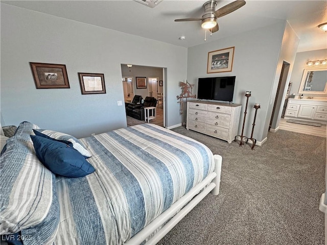 carpeted bedroom featuring connected bathroom, baseboards, and a ceiling fan