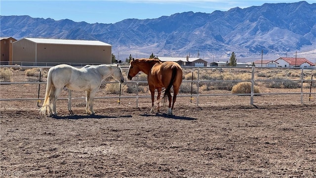 view of horse barn with a mountain view and a rural view