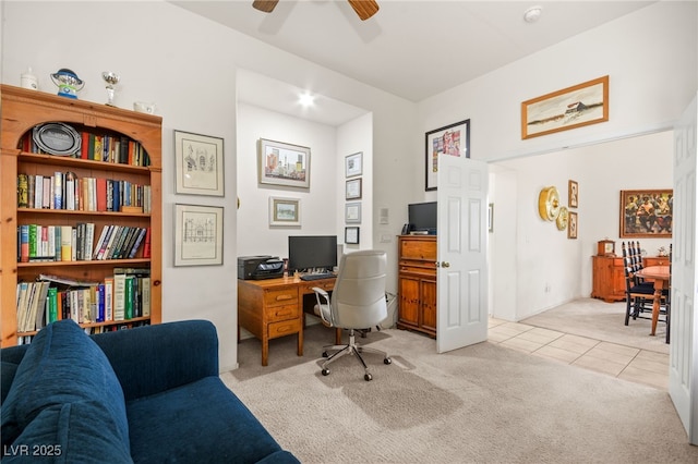 home office featuring light tile patterned floors, a ceiling fan, and light carpet