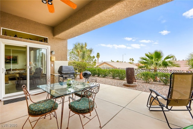 view of patio / terrace with outdoor dining area, a ceiling fan, and a grill