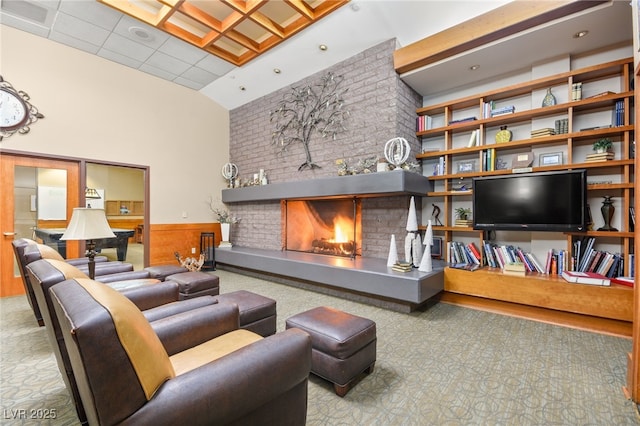 living area featuring visible vents, wainscoting, a fireplace, and a high ceiling