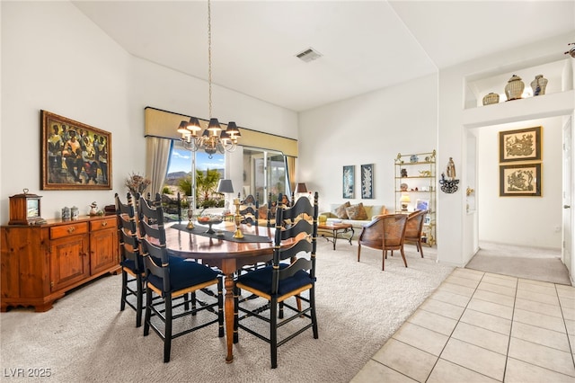 dining area with light tile patterned flooring, visible vents, light colored carpet, and an inviting chandelier