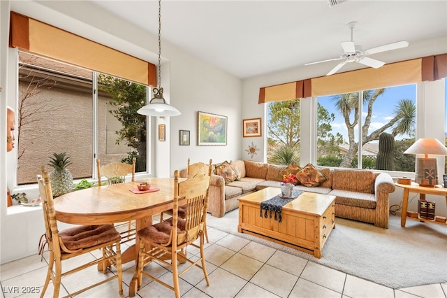 dining area featuring light tile patterned floors, light colored carpet, and ceiling fan