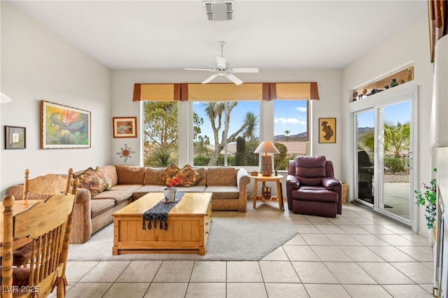 living room featuring light tile patterned floors, a ceiling fan, and visible vents