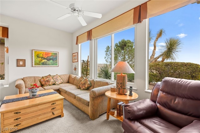 living area featuring a wealth of natural light, light colored carpet, and ceiling fan