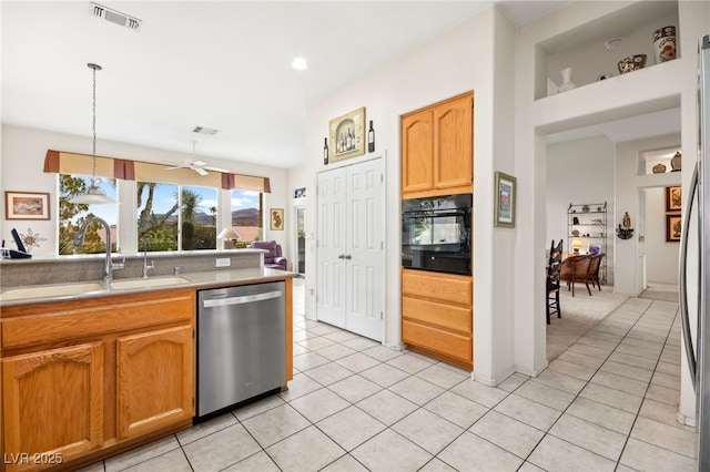 kitchen featuring visible vents, a sink, black oven, stainless steel dishwasher, and light tile patterned floors