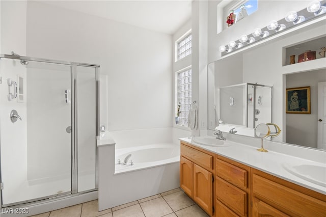 full bathroom featuring a garden tub, double vanity, a stall shower, a sink, and tile patterned floors