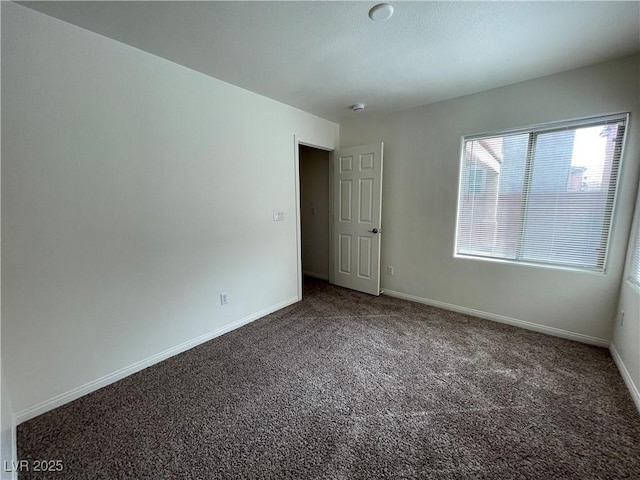 unfurnished room with carpet flooring and baseboards