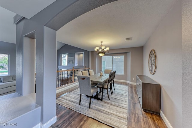 dining area with a notable chandelier, wood finished floors, visible vents, and a healthy amount of sunlight