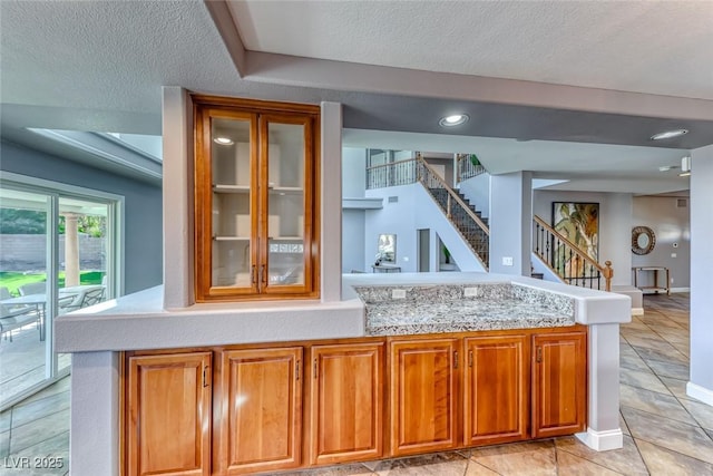 bar with light tile patterned floors, baseboards, a textured ceiling, and stairs