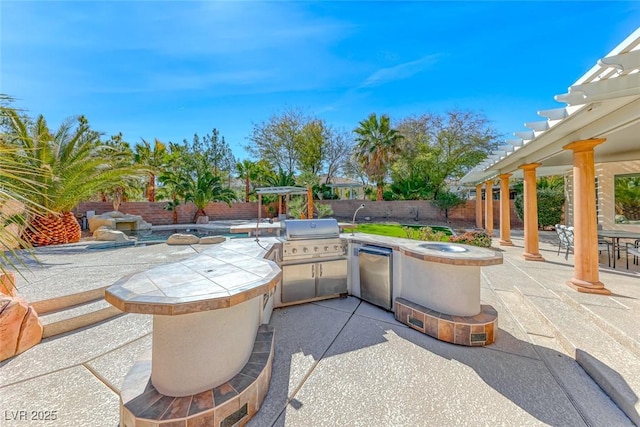 view of patio / terrace featuring area for grilling, a fenced backyard, and an outdoor kitchen