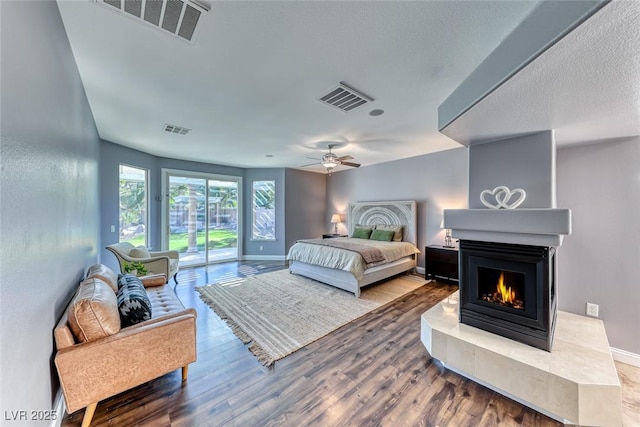 bedroom with access to exterior, wood finished floors, and visible vents