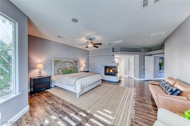 bedroom featuring visible vents, baseboards, and wood finished floors