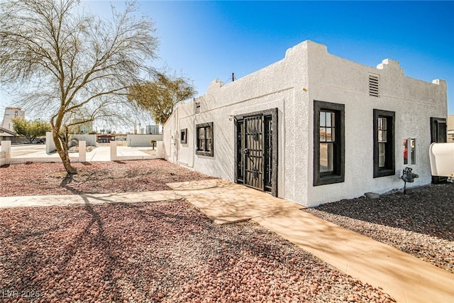 view of home's exterior with stucco siding, heating fuel, and a patio area