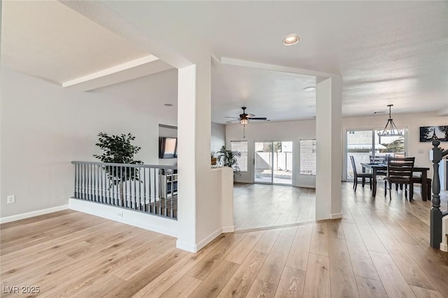 hallway featuring baseboards and light wood finished floors