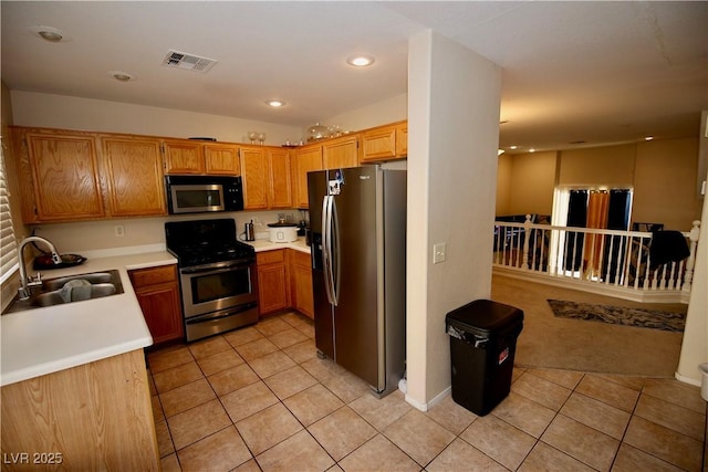 kitchen with a sink, visible vents, appliances with stainless steel finishes, and light tile patterned floors