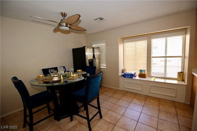 dining space featuring light tile patterned floors, visible vents, baseboards, and ceiling fan