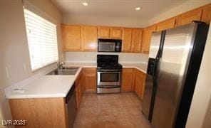 kitchen with a sink, appliances with stainless steel finishes, recessed lighting, and light countertops